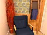 a blue chair in the corner of a room next to a towel rack