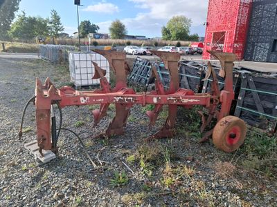 un tracteur rouge équipé d'une charrue