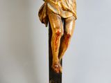 a statue of jesus on a cross on a wooden pole