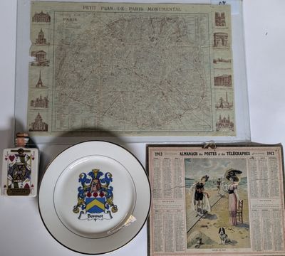 a plate with a coat of arms on it next to a plate with a picture on it