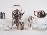 beaucoup de théières et de tasses en argent sur la table