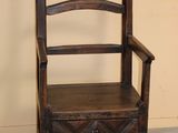 a wooden chair with a drawer underneath it in a room