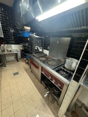 a kitchen with a stove, sink, and oven in it