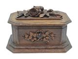 boîte en bois sculptée, ornée de fleurs et de feuilles sur fond blanc