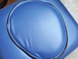 a blue chair with a seat that has a black handle