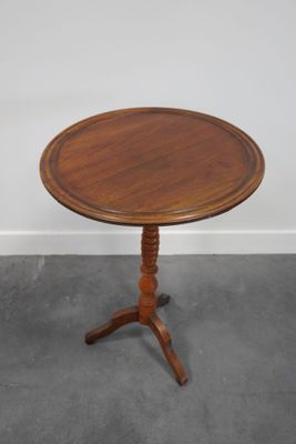 une petite table en bois avec un plateau en bois, posée sur un sol gris
