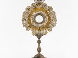 a silver and gold clock with a crown on top of it