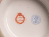 a close up of a white bowl with a red and blue stamp on it