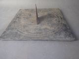 a sundial on a table with a clock on it
