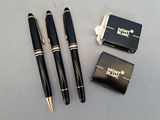 two pens and a lighter are sitting next to each other on a table