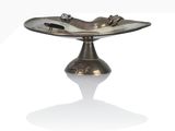 a silver plate with a bird on it on a stand