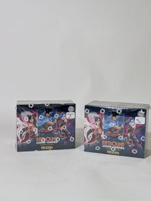 Deux boîtes de cartes à collectionner Pokémon sont posées sur une surface blanche.