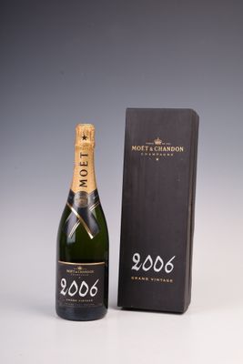 une bouteille de champagne Moët & Brandon à côté d'une boîte