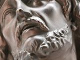 a bronze statue of a man with a crown of thorns on his head