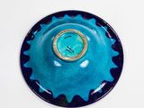 a blue bowl with a gold rim on a white table