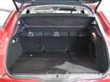 the back of a red car with its trunk open and luggage in the trunk