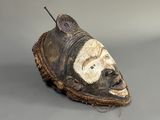 un gros plan d'un masque posé sur une surface grise