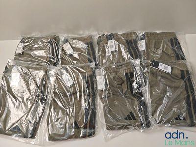 six sacs de vêtements emballés dans du plastique, posés sur une table