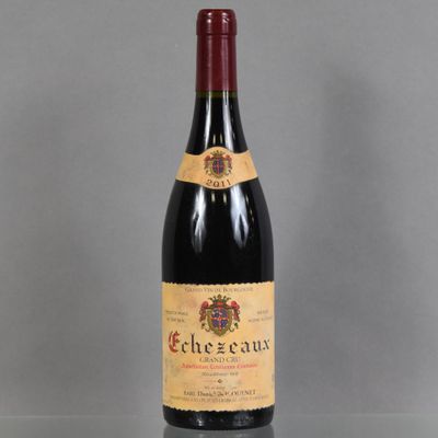 the bottle of red wine is sitting on a glass table