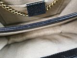 the inside of a black purse with a gold chain hanging from it