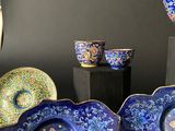 many plates and bowls on display on a black table