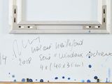a white board with writing on it next to a window