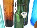 several different colored glass bottles are lined up on a white surface