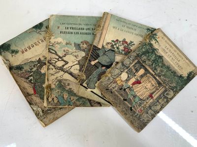trois vieux livres pour enfants posés sur une table blanche