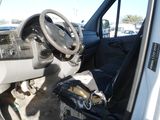 a white van with a steering wheel and a bag in the passenger seat