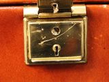 an image of a brown suitcase with a clock on it