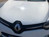 the front of a white car is parked in a parking lot