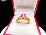 a pink diamond ring in a red box on a white surface