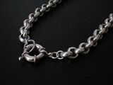 a close up of a silver chain with a heart on it