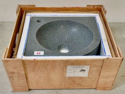 une caisse posée par terre, avec un lavabo à l'intérieur
