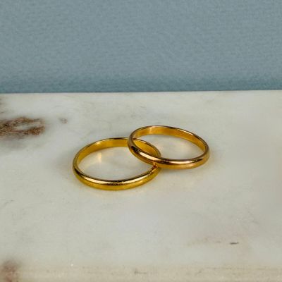 two gold wedding rings on a marble slab