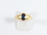 une image d'une bague en or avec une pierre bleue