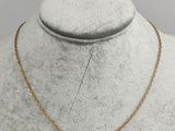 a gold necklace with a blue stone on a mannequin mannequin