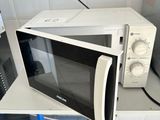 a microwave sitting on top of a counter next to a refrigerator