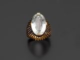 une bague en or sertie d'une topaze blanche ovale sur fond noir