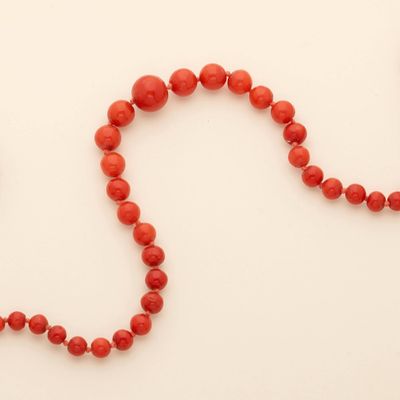 an image of a red beaded necklace on a white surface