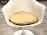 a white chair with a cushion on it in a room