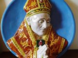 une figurine en céramique représentant un pape tenant une rose