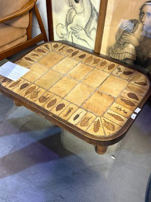 a wooden table with a tile top and a picture on it