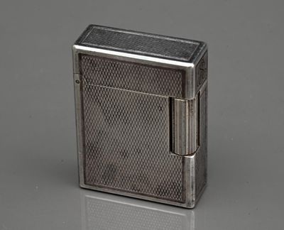 un vieux briquet en argent posé sur une surface réfléchissante