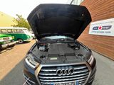 une voiture dont le capot est ouvert et qui est garée devant un immeuble