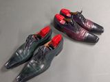 three pairs of men ' s shoes are lined up on a table