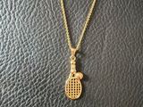 un collier en forme de raquette de tennis en or sur un mannequin, un mannequin, un mannequin, un mannequin, un mannequin, un mannequin, un mannequin, un mannequin