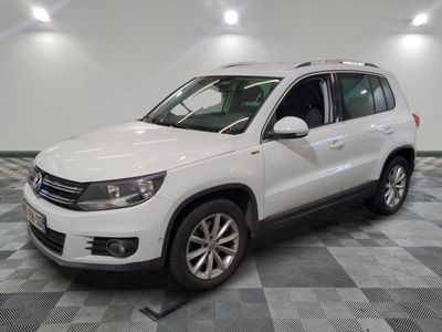 La Volkswagen Tiguan blanche est garée sur un sol en carrelage à damier.