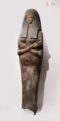 une vieille statue en bois représentant une femme les bras croisés