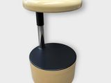 une image d'un tabouret avec une assise noire et une assise jaune